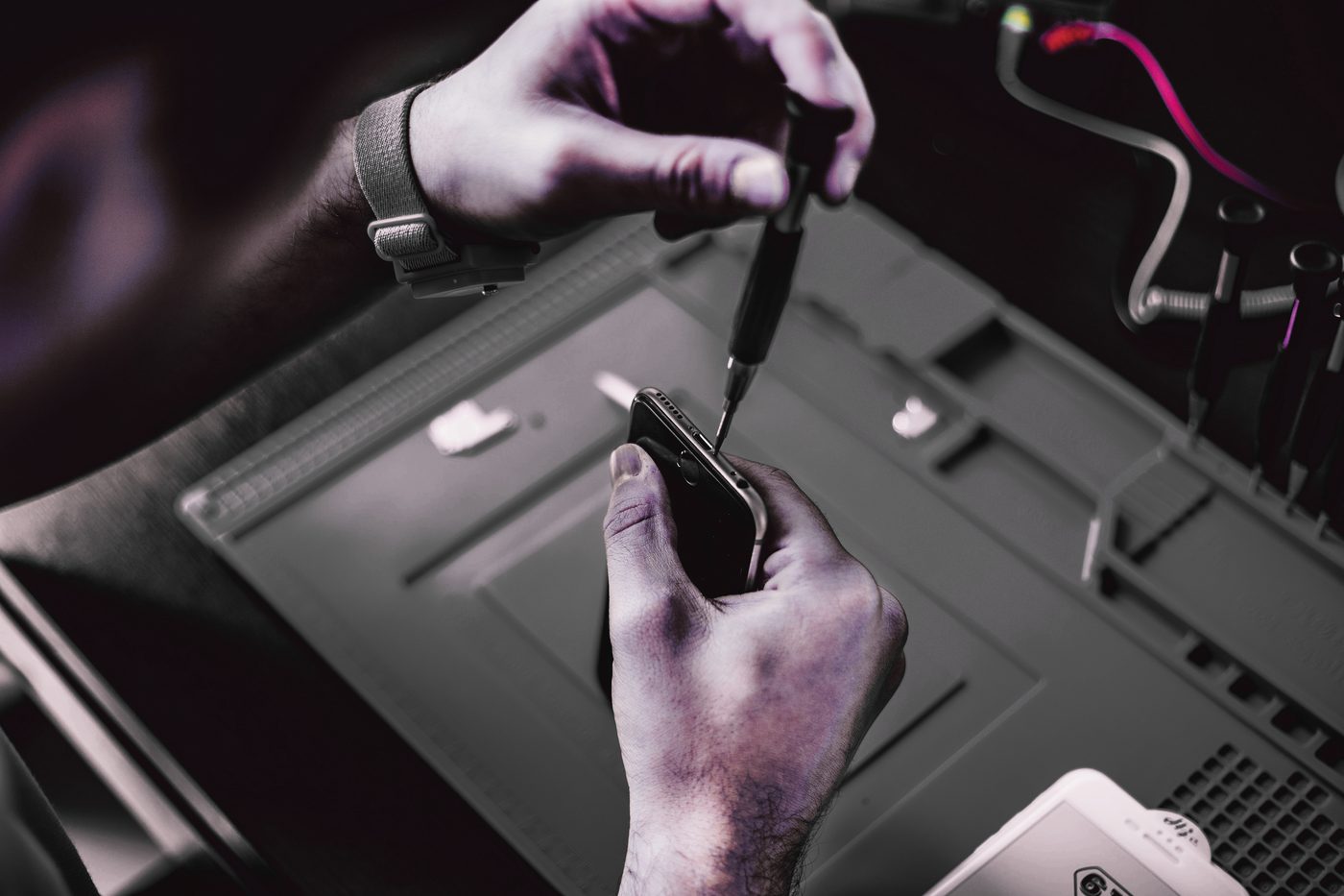 Stagiaire en cours de réparation d'un smartphone à l'atelier Fixit Formation